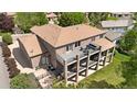 A view of a multi-tiered deck with outdoor seating, overlooking a lush backyard, and complementing the brick exterior of the home at 2595 S Harlan Ct, Lakewood, CO 80227