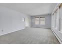 Spacious living room with light walls, carpet, and large windows at 12341 E Cedar Cir, Aurora, CO 80012