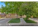 Charming home featuring a well-manicured lawn, beautiful mature trees, and a welcoming front entrance at 2518 S Patton Ct, Denver, CO 80219