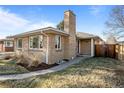 Brick home showcasing a side view with mature shrubs at 2885 Hudson St, Denver, CO 80207