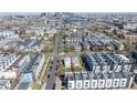 This aerial view shows the house surrounded by modern townhomes with the Denver skyline in the background at 1745 Irving St, Denver, CO 80204