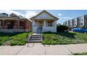 Charming bungalow with a covered front porch, stone steps, and a well-maintained lawn and mature shrubbery at 1745 Irving St, Denver, CO 80204