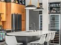 A modern kitchen has a large island with seating, sleek countertops, and wine refrigerators at 3133 Blake St # 3, Denver, CO 80205