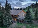 Aerial view of a home featuring a hot tub and spacious back deck, enveloped by pine trees at 96 Carolyn Rd, Evergreen, CO 80439