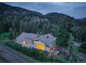 Beautiful aerial view of a home in the mountains surrounded by lush trees and a scenic view at 96 Carolyn Rd, Evergreen, CO 80439