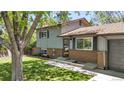 Charming home with brick accents, neutral siding, mature landscaping, and a concrete front walkway at 1250 Acropolis Dr, Lafayette, CO 80026