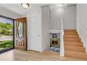 Bright foyer featuring wood floors, a decorative front door, and stairway to the second floor at 1250 Acropolis Dr, Lafayette, CO 80026