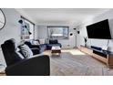 Modern living room with sectional sofa, large TV, and hardwood floors at 3126 S Franklin St, Englewood, CO 80113