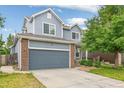 Charming two-story home features blue siding, brick accents, and an attached two-car garage at 15762 Olmsted Pl, Denver, CO 80239
