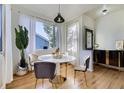 Bright dining room with large window, round table with gold accents and natural light at 4689 Tanner Peak Trl, Brighton, CO 80601