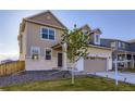 Charming two-story home with a two-car garage and well-maintained front yard with grass and rock at 9099 Sedalia St, Commerce City, CO 80022