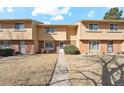 A townhouse with a well-kept front lawn and a walkway leading to the front door at 1177 S Troy St, Aurora, CO 80012