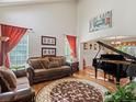 Bright living room features high ceilings, hardwood floors, a piano, and comfortable seating at 6293 Braun Cir, Arvada, CO 80004