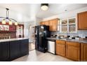 View of the kitchen with granite counters, stainless appliances and adjoining dining area at 4627 S Norfolk Way, Aurora, CO 80015