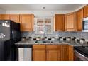 Kitchen features stainless steel appliances, granite countertops, and wood cabinets at 4627 S Norfolk Way, Aurora, CO 80015