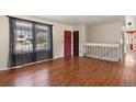 Bright living room featuring hardwood floors, large windows, and modern railing at 4627 S Norfolk Way, Aurora, CO 80015