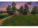 A stunning backyard featuring lush grass, mature trees, a pergola, a water feature, and an outdoor gazebo at 6940 Saddleback Ave, Firestone, CO 80504