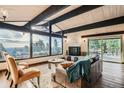 Bright and spacious living room featuring a stone fireplace, wood floors, and a scenic view at 21437 Alta Dr, Morrison, CO 80465