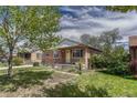 Quaint brick house showcases a covered entrance, small front yard, and inviting curb appeal at 1334 Xavier St, Denver, CO 80204