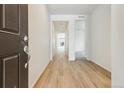 Bright hallway featuring wood floors and white walls at 9673 Ceylon St, Commerce City, CO 80022