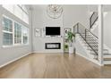 Bright living room with tall ceilings, large windows, modern fireplace, and wood floors at 3026 S Waco Ct, Aurora, CO 80013