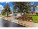 Charming two-story home with well-manicured lawn, driveway, and lush landscaping with mature trees at 10370 Routt St, Westminster, CO 80021