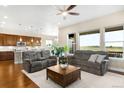 Cozy living room featuring two plush sofas, a ceiling fan, and a view of the plains at 15779 W 83Rd Pl, Arvada, CO 80007