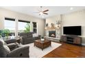 Bright living room featuring a stone fireplace, hardwood floors, and a flat-screen TV at 15779 W 83Rd Pl, Arvada, CO 80007