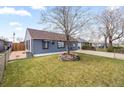 Inviting single-level home featuring a green lawn and mature tree in the front yard at 4849 N Cook St, Denver, CO 80216