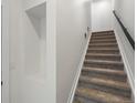 Interior view of a carpeted staircase with modern black metal handrail and an open wall niche at 2042 S Holly St # 3, Denver, CO 80222