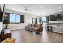 Open-concept living area with dark wood floors, sleek black window shutters, and an airy ambiance at 1702 Metcalf Dr, Erie, CO 80516
