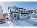 Two-story house with gray siding, stone accents, and a two-car garage at 39260 Braxton Ln, Elizabeth, CO 80107
