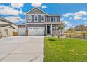 Beautiful two-story home featuring a three-car garage, manicured lawn, and inviting front porch at 18338 Field Mint Pt, Parker, CO 80134