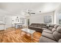 Open living room with wood floors, a gray sectional sofa, and lots of natural light at 21562 E 47Th Ave, Denver, CO 80249