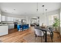 Bright, open kitchen with stainless steel appliances, a blue island with barstool seating and adjacent dining area at 14025 Blue River Trl, Broomfield, CO 80023
