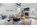 Inviting living room featuring a fireplace, ceiling fan, hardwood floors, and stylish decor at 14025 Blue River Trl, Broomfield, CO 80023