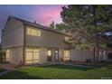 Charming townhome with a well-maintained lawn and appealing exterior features at dusk at 4273 W Ponds Cir, Littleton, CO 80123