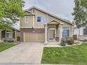 Charming two-story home with brick accents, attached garage, landscaped yard, and neutral siding at 5319 Morning Glory Pl, Highlands Ranch, CO 80130