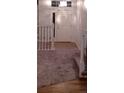 Hallway featuring new carpet, and white railing with dark spindles and new flooring at 5319 Morning Glory Pl, Highlands Ranch, CO 80130