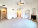 Spacious living room featuring neutral walls, carpet flooring, vaulted ceiling and a cozy fireplace at 3231 E 102Nd Pl, Thornton, CO 80229
