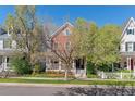 Charming brick home with a inviting front porch and manicured lawn, perfect for relaxing at 2831 Spruce St, Denver, CO 80238