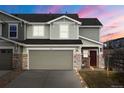 Charming home featuring a two-car garage, stone accents and craftsman details at sunset at 5671 Raleigh Cir, Castle Rock, CO 80104