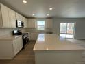 Bright kitchen featuring white cabinets, stainless steel appliances, and a spacious quartz island at 22077 E 39Th Pl, Aurora, CO 80019