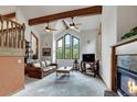 Bright living room with vaulted ceiling, wood beams, large windows offering mountain views, and a cozy fireplace at 322 Davis Ct, Breckenridge, CO 80424