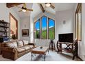 Bright living room with vaulted ceilings, wood beams, and mountain views from the beautiful, large picture windows at 322 Davis Ct, Breckenridge, CO 80424