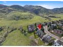 Aerial view of house in green neighborhood near mountains with a cul-de-sac at 87 Deerwood Dr, Littleton, CO 80127