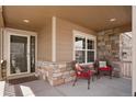 Cozy front porch with stone accents and seating area at 5172 Purple Mustard Ct, Brighton, CO 80601