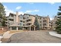Inviting exterior of a multi-story condo building with stone accents and manicured landscaping at 31719 Rocky Village Dr # 317, Evergreen, CO 80439