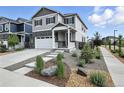 Charming two-story home with gray siding, stone accents, a two-car garage, and attractive landscaping at 27504 E 1St Pl, Aurora, CO 80018