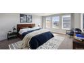 Comfortable bedroom with a large bed, soft carpet, three windows, and stylish decor at 1102 Ridgefield Dr, Berthoud, CO 80513